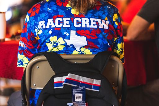 A closeup shot of the text "race crew" printed on a man's shirt