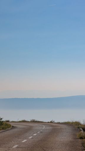 A vertical shot of a road with a sea in the background in Dalmatia, Croatia