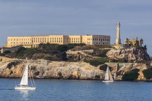 The floating sailboats with a lighthouse on the horizon