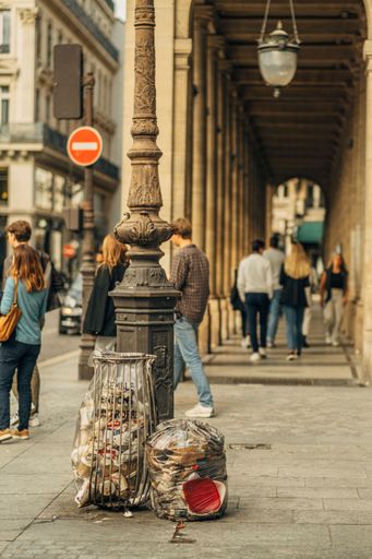 A vertical shot of the city life with trash bags in the streets of Paris, France