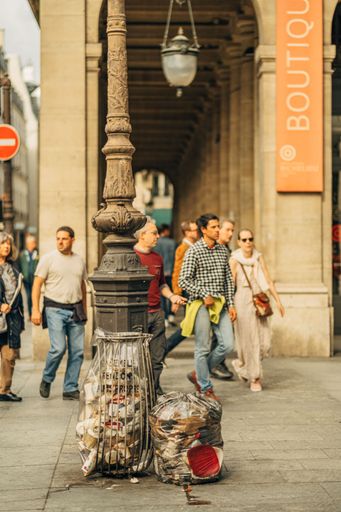 A vertical shot of the city life with trash bags in the streets of Paris, France