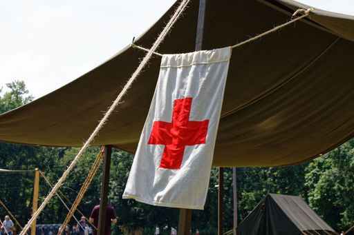 A closeup shot of a hanging first aid flag with a cross in a tent