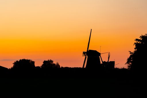 A beautiful shot of a windmill on an amazing sky background during the sunset