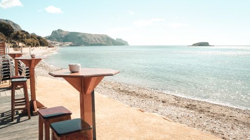 A cafe with seats and tables on the shore at daytime