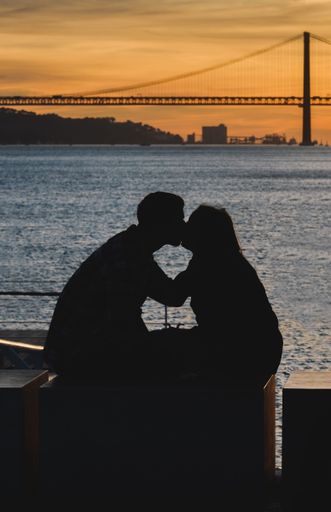 The silhouette of a kissing couple with seascape on the background