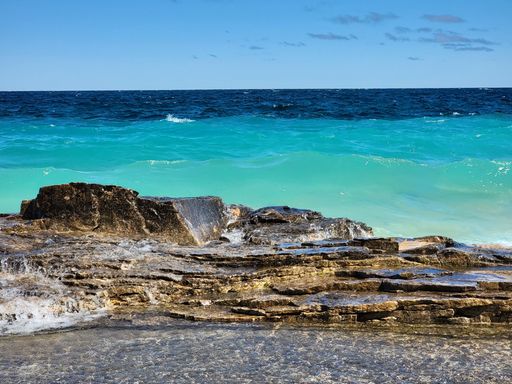 A natural view of rocky cliff and beautiful coast under a sunny day during summer