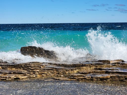 A natural view of rocky cliff and beautiful coast under a sunny day during summer