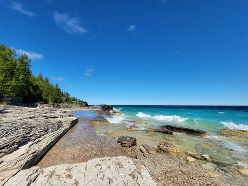 A natural view of rocky cliff and beautiful coast under a sunny day during summer