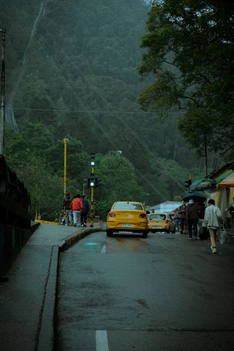 A vertical shot of the streets of Bogota with yellow taxi cars on a rainy moody day
