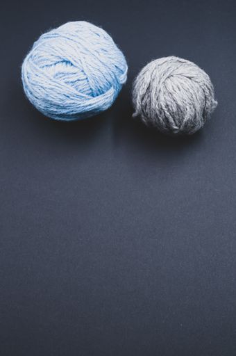 Two wool and cotton yarns on a black background