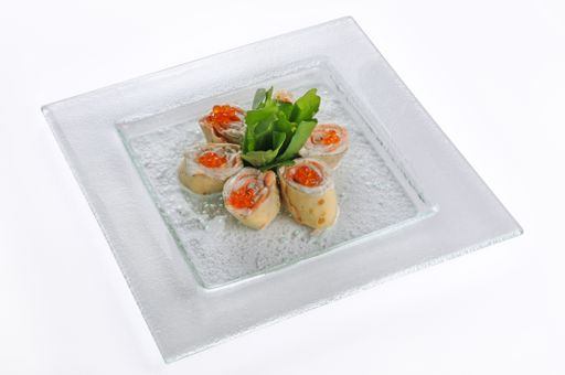 An isolated shot of a white plate of pancake rolls with red caviar - perfect for a food blog or menu usage