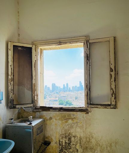 A vertical shot of an open window in an old house