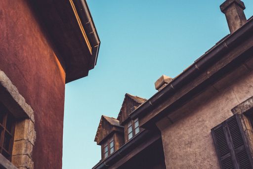 A low angle shot of an old neighborhood with concrete houses under the clear blue sky