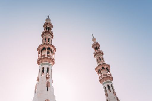 A low angle shot of two steeples under the beautiful bright sky