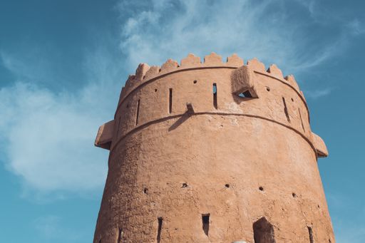 A low angle shot of a concrete historic castle under the beautiful cloudy sky