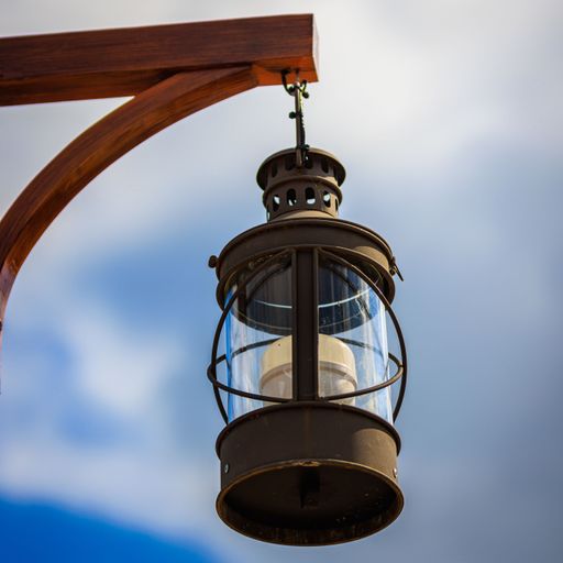 A low angle shot of a hanging vintage lamp on a wooden pole