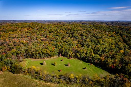An aerial drone view of a beautiful forest at Hartwood Acres park under a blue sky on a sunny day
