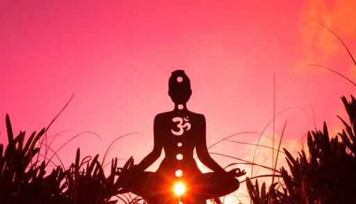 A silhouette of a person doing yoga with the root chakra symbol