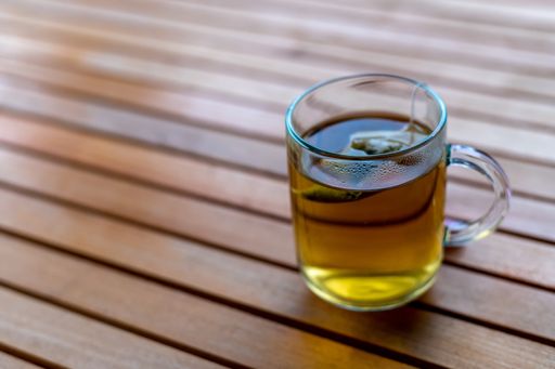 A high angle shot of a cup of tea on a wooden table