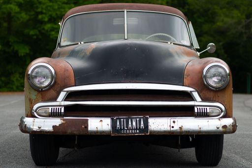The frontal view of an old rusty Chevrolet Deluxe with Atlanta plate