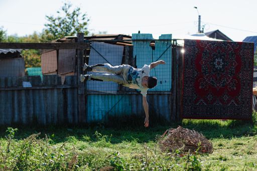 A boy performing a stunt in a rural area