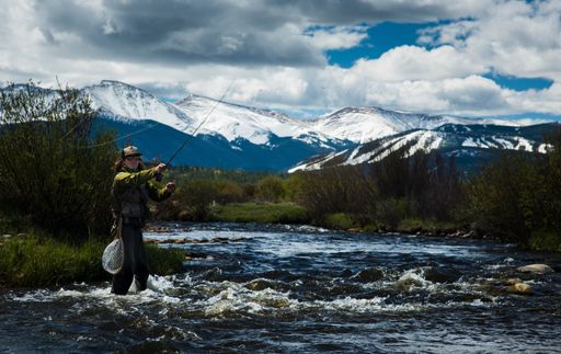 A man holding a fishing rod while standing in Fraser River