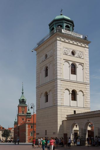 A vertical shot of historic bell tower of the church of St. Anna. and the royal castle in Warsaw, Poland