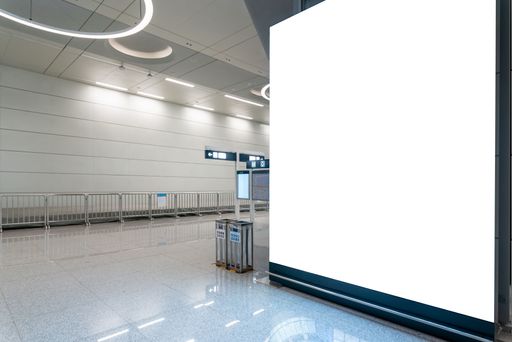 A closeup of an empty billboard in a modern subway corridor