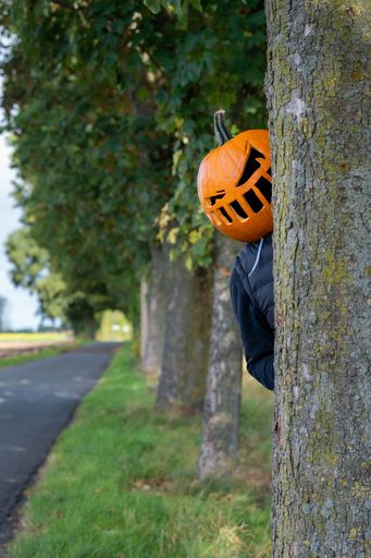A vertical shot of a person with a pumpkin head.