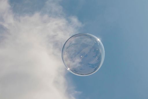 A closeup shot of a soap bubble in the clear blue sky