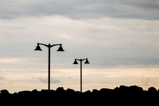 A silhouette shot of a street lights on the cliff