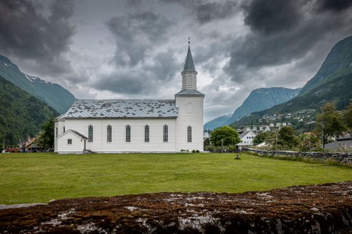 A church at Odda in Norway with a background of dark sky and mountains