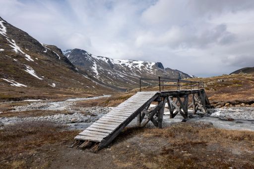 A beautiful shot of a bridge over a stream on Visladen valley in Piterstulen,Jotunheimen,Norway