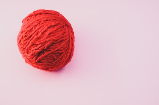 A high angle shot of a ball of red yarn