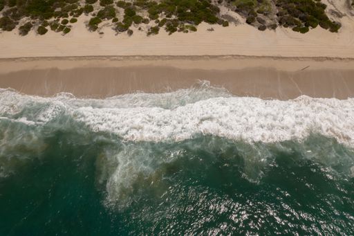 An aerial view of the splashing sea waves at the shore