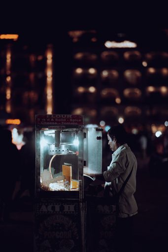 A dramatic vertical shot of the popcorn vendor at night in the city