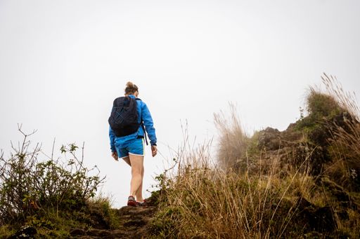 A young female with backpack walking along in the forest