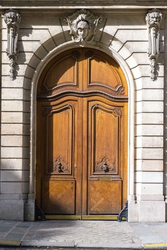 Paris, an ancient sculpted door, beautiful facade in a luxury neighborhood