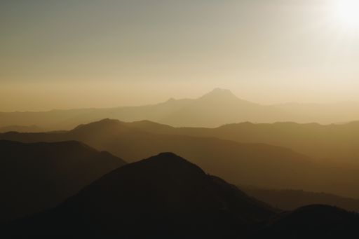 An aerial shot of a breathtaking sunset over a beautiful mountainous scenery