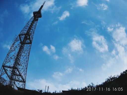 A low angle shot of an observation tower under the cloudy sky