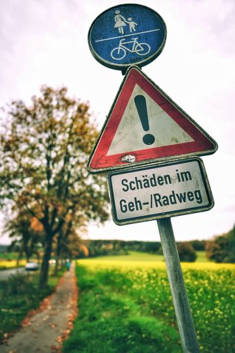 A street sign of sidewalk is shared by pedestrians and cyclists with german text, vertical shot