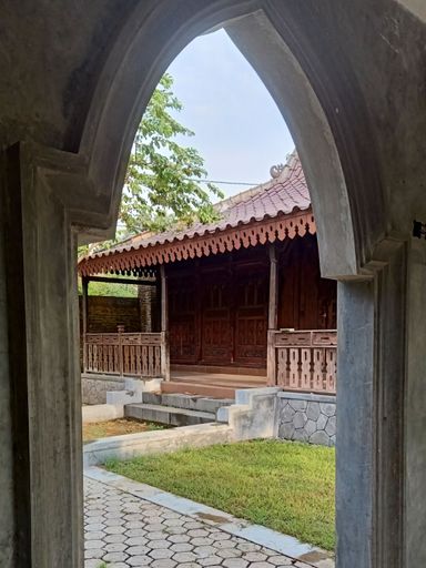 front view of a traditional Javanese wooden house front view of a traditional Javanese wooden house framed by a concrete gate