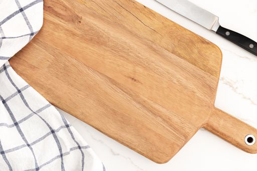 A shot of empty cutting board on white marble background