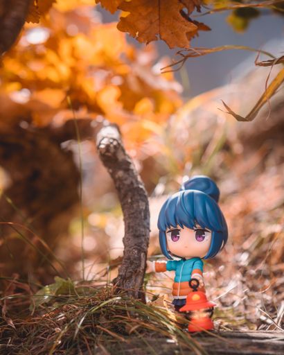 A nendoroid figurine of Rin Shima from Yuru Camp holding a lamp and exploring the autumn foliage