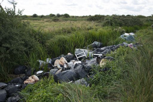 Fly tipping in drainage ditch on Crayford Marshes, Bexley, South East London, UK