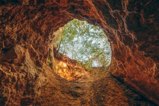 A low angle shot of a round hole as a cave entrance