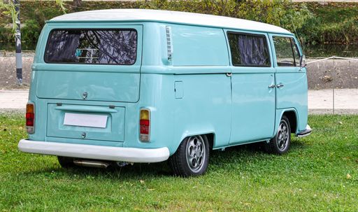 A beautiful turquoise classic Volkswagen Kombi van during an exhibition in a park