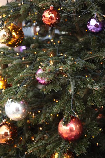 A closeup shot of a Christmas tree with beautiful decorative balls and lights