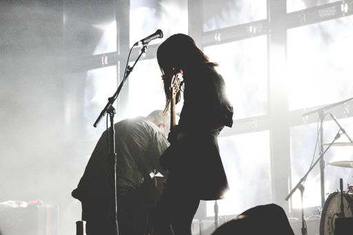 Silhouette of female bass player on stage