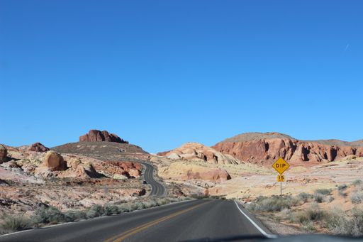 winding highway in the desert with road sig